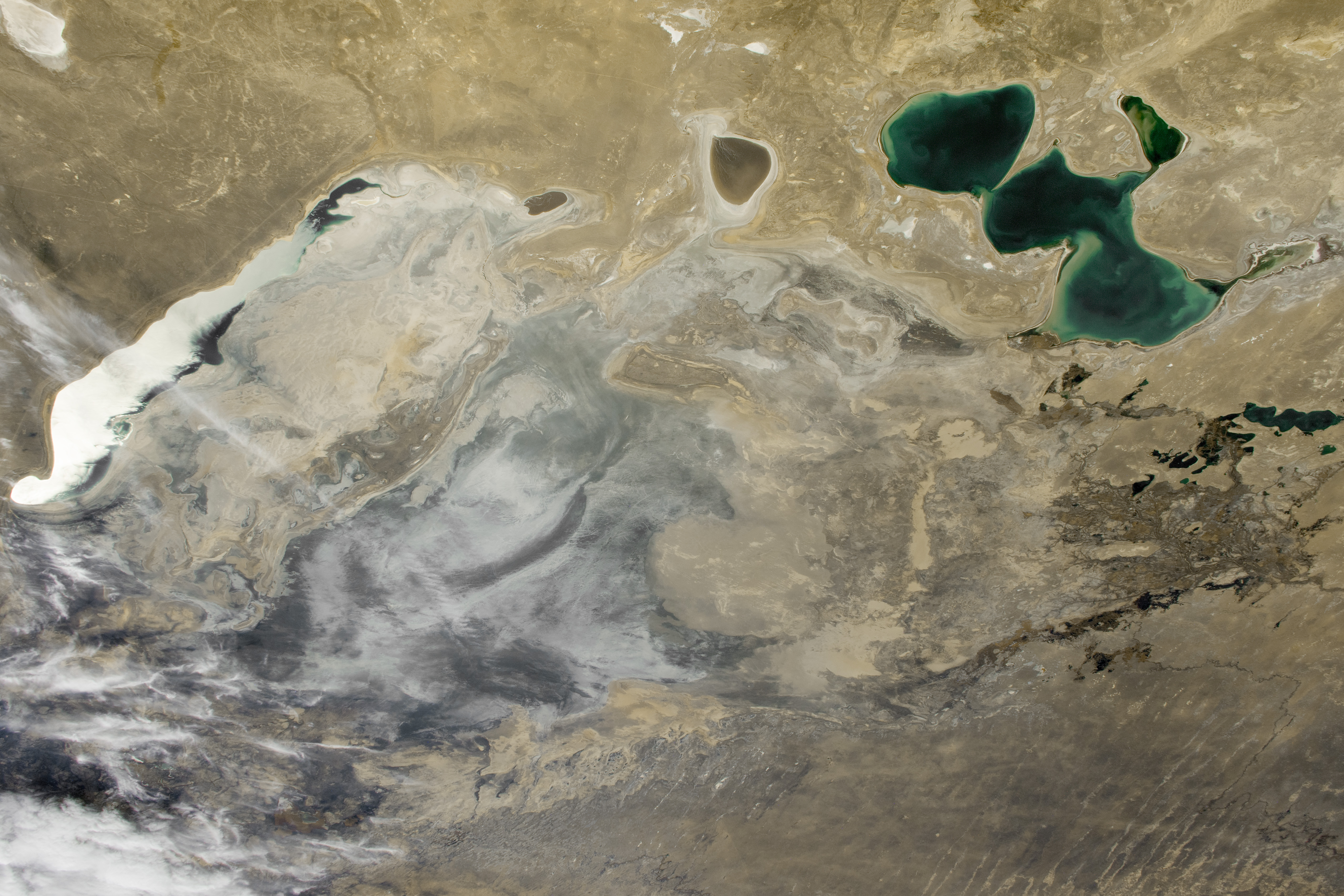 birds-eye view of a tan and white desert with a small body of water