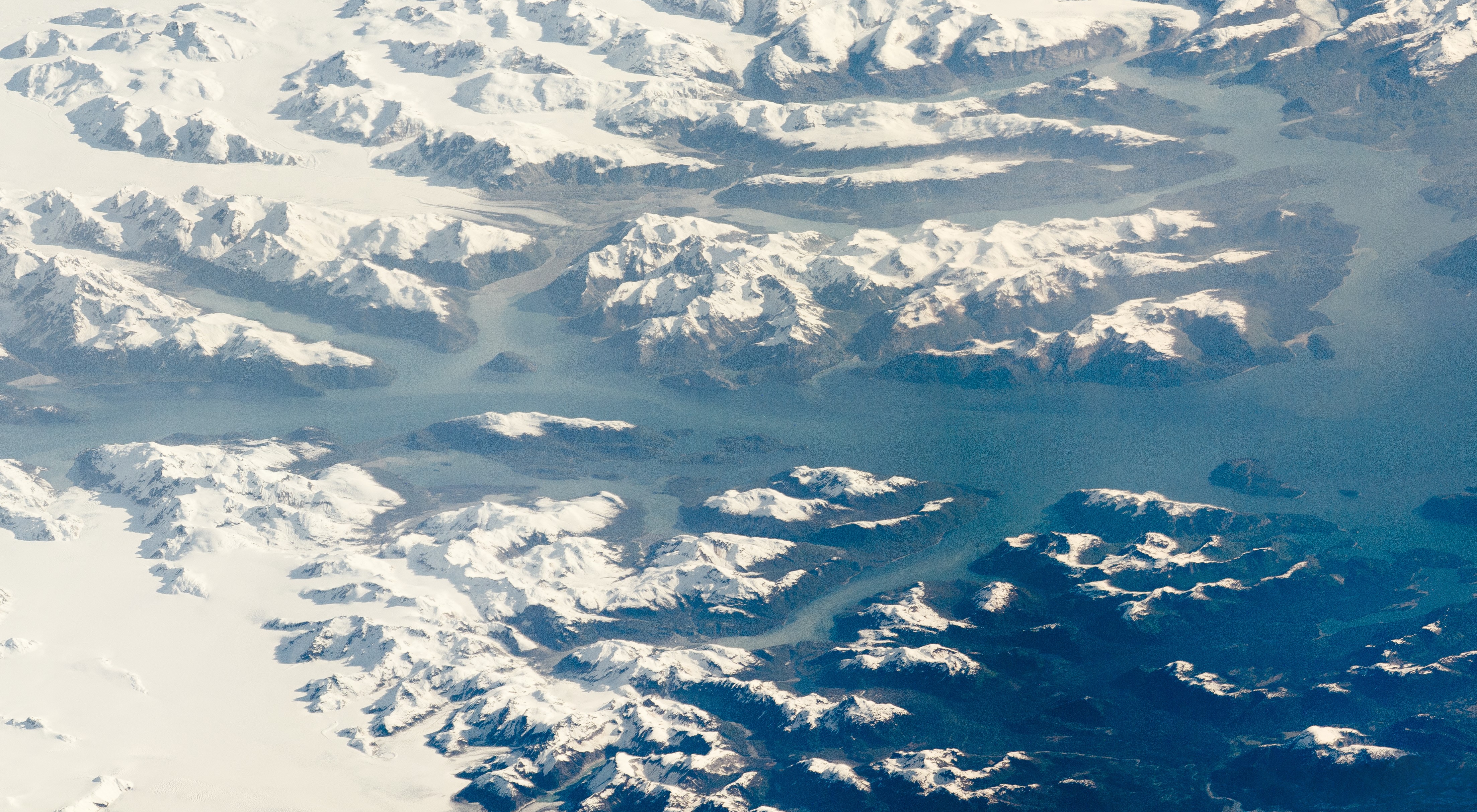 a snowy mountain range with a river surrounding the mountain