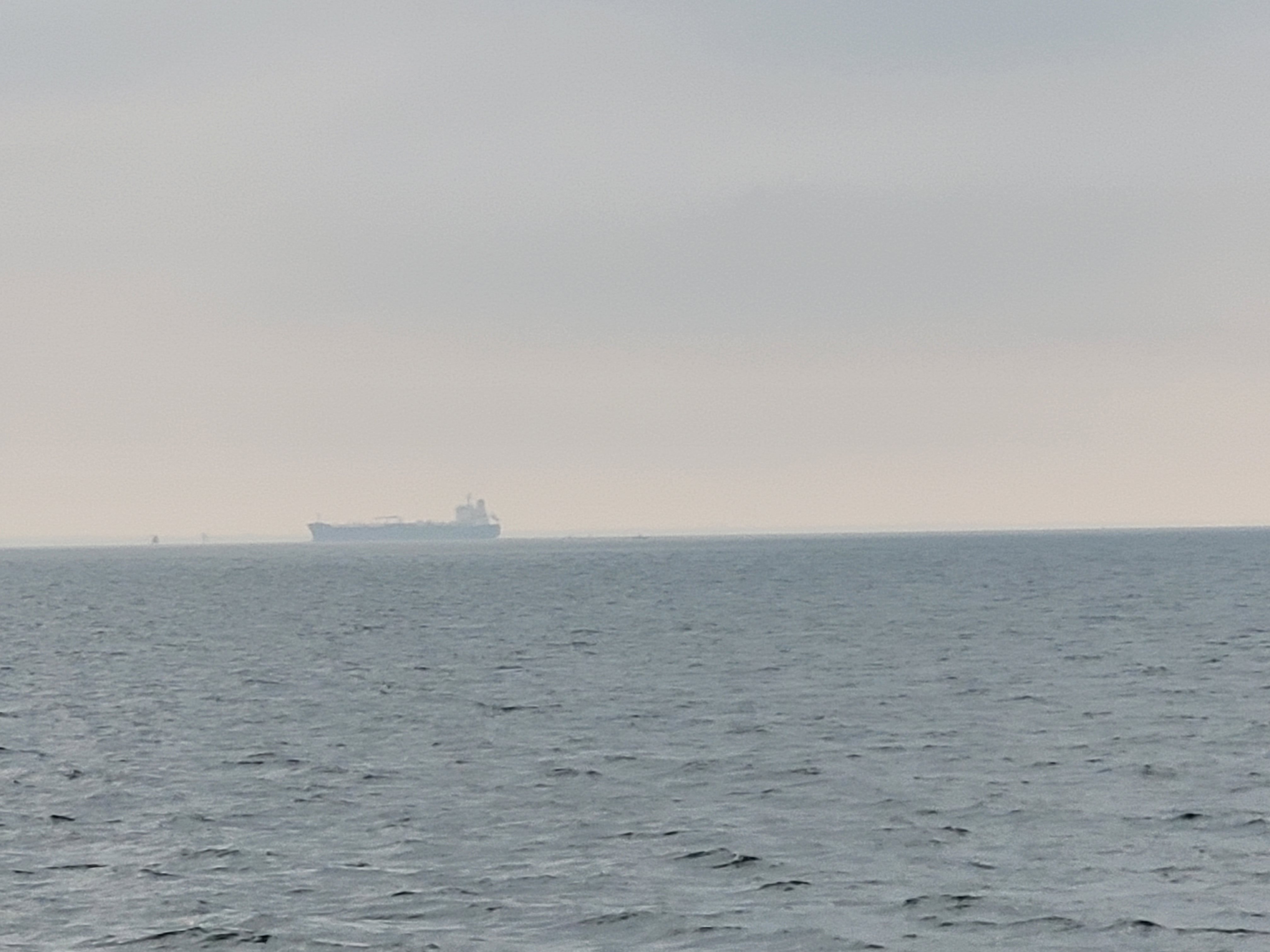 eerie foggy weather with a frieght ship way off in the distance
